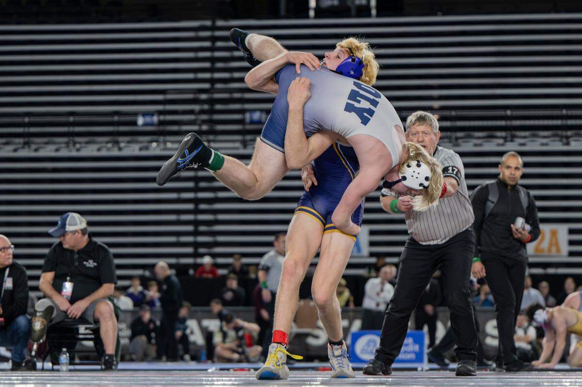 Sumner’s Cody Miller picks up Olympia’s Landon Porter in the 157-pound 4A championship during day two of the Mat Classic XXXV at the Tacoma Dome on Saturday, Feb. 17, 2024, in Tacoma, Washington.