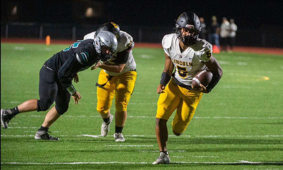 Lincoln quarterback Gabarri Johnson scores a first-half touchdown on a keeper as Lincoln played Spanaway Lake in a 3A PCL football game at Art Crate Field on Thursday, Sept. 23, 2021.