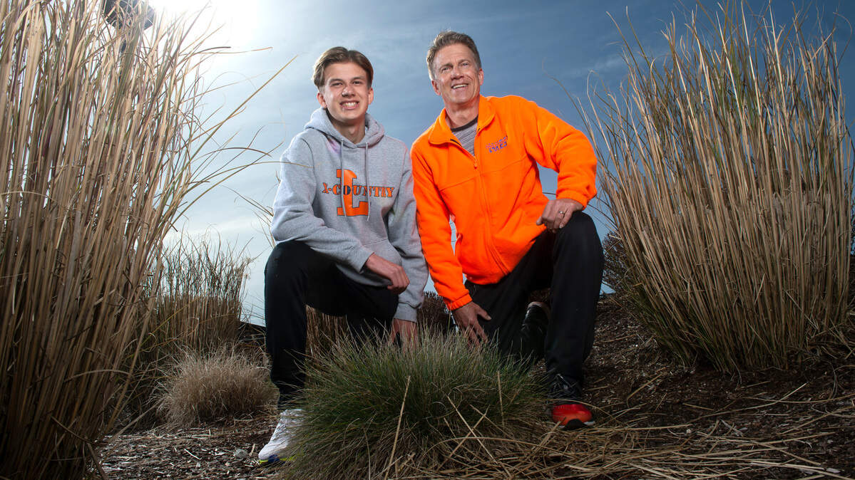 Lakes High School sophomore cross country runner Cruize Corvin and his father, Curt Corvin, at Lakes High School in Lakewood, Washington, on Tuesday, March 16, 2021.. Cruize has the top time in Pierce County this spring and one of the top time’s in the state. Curt has returned to help coach at Lakes, where he was a Hall of Fame runner in the 1980s.