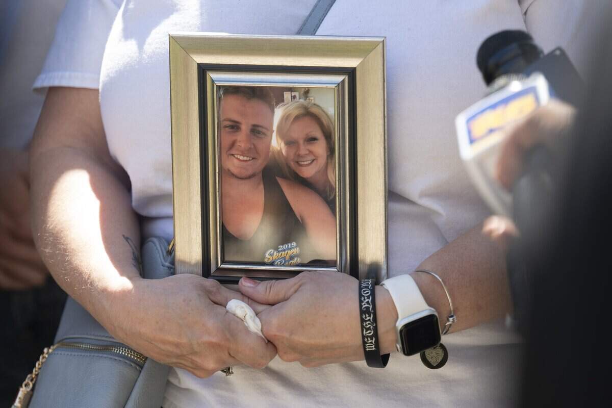 Laura Zimmerman, Sean Miller's mother, holds a framed selfie of her and her son while speaking with the media after the arraignment of Chaston Pierce Philes on Tuesday, July 14, 2026, at Pierce County Superior Court in Tacoma, Wash. Philes was arraigned on charges of second-degree murder in the July 15, 2024 fatal shooting of Miller.
