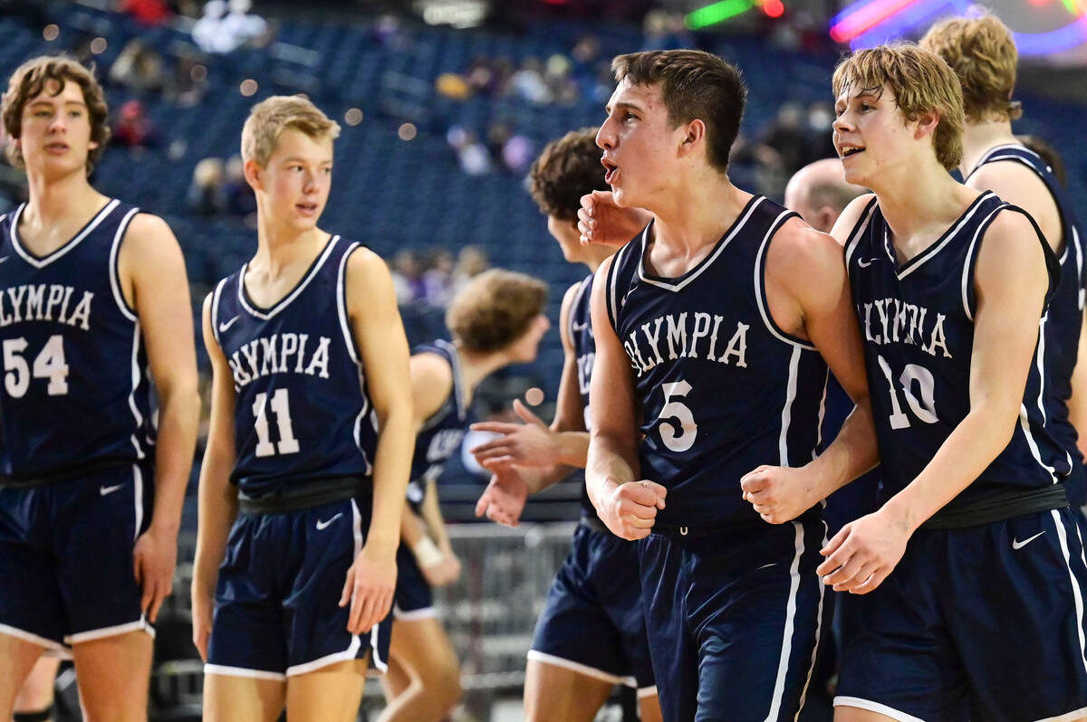 Olympia players celebrate after beating Tahoma, 60-53, in a Class 4A quarterfinal state tournament game on Thursday, March 3, 2022, at the Tacoma Dome, in Tacoma, Wash.