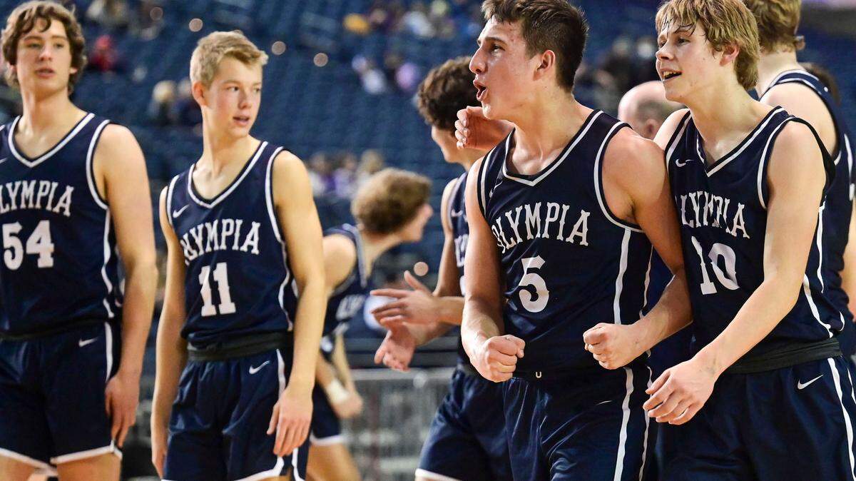 Olympia players celebrate after beating Tahoma, 60-53, in a Class 4A quarterfinal state tournament game on Thursday, March 3, 2022, at the Tacoma Dome, in Tacoma, Wash.