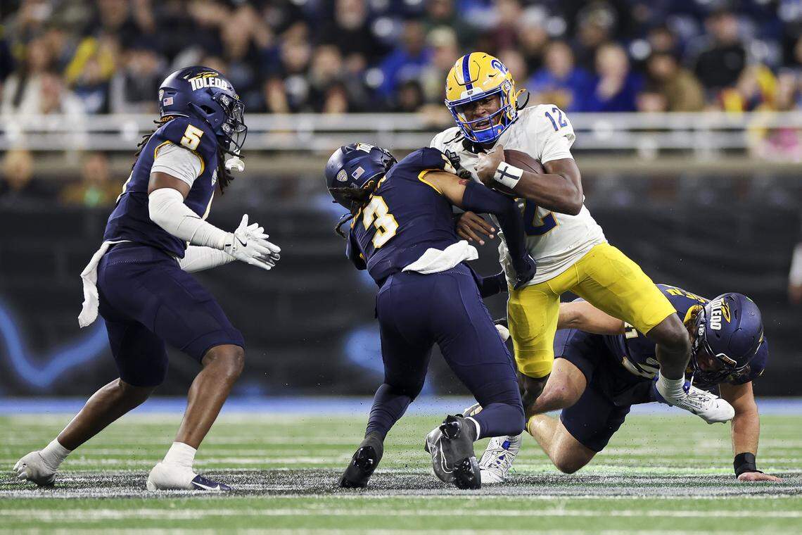 DETROIT, MICHIGAN - DECEMBER 26: Julian Dugger #12 of the Pittsburgh Panthers tries to break a tackle by Andre Fuller #3 of the Toledo Rockets in the fourth quarter of the GameAbove Sports Bowl game at Ford Field on December 26, 2024 in Detroit, Michigan. (Photo by Mike Mulholland/Getty Images)