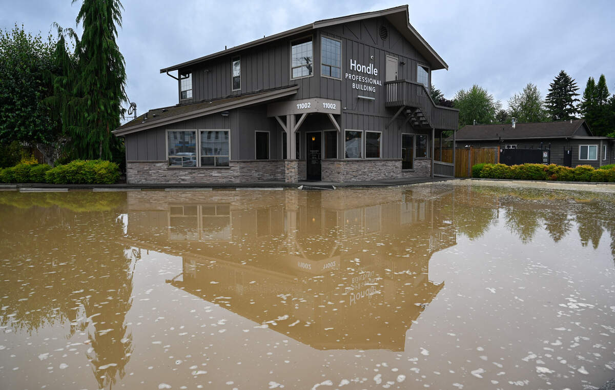 Handle Professional Building’s parking lot sits flooded after a water main broke at the corner of Valley Avenue East and Milwaukee Avenue East in Puyallup, Wash., on Monday, July 29, 2024.