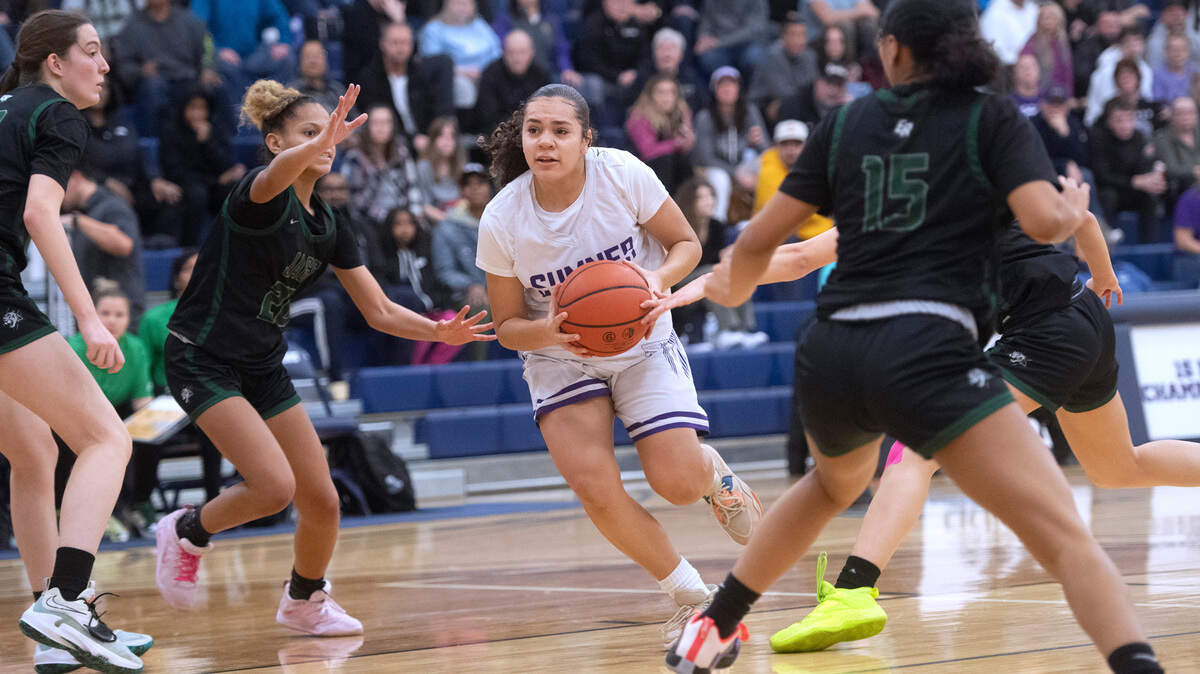 Sumner’s Olivia Collins drives the lane between Emerald Ridge defenders Naleila Cammack and Tami Gallo (15) during Saturday night’s 4A SPSL girls basketball tournament championship game at Tacoma Community College in Tacoma, Washington, on Feb. 4, 2023. Sumner held off a late Emerald Ridge rally to win the game, 50-48.