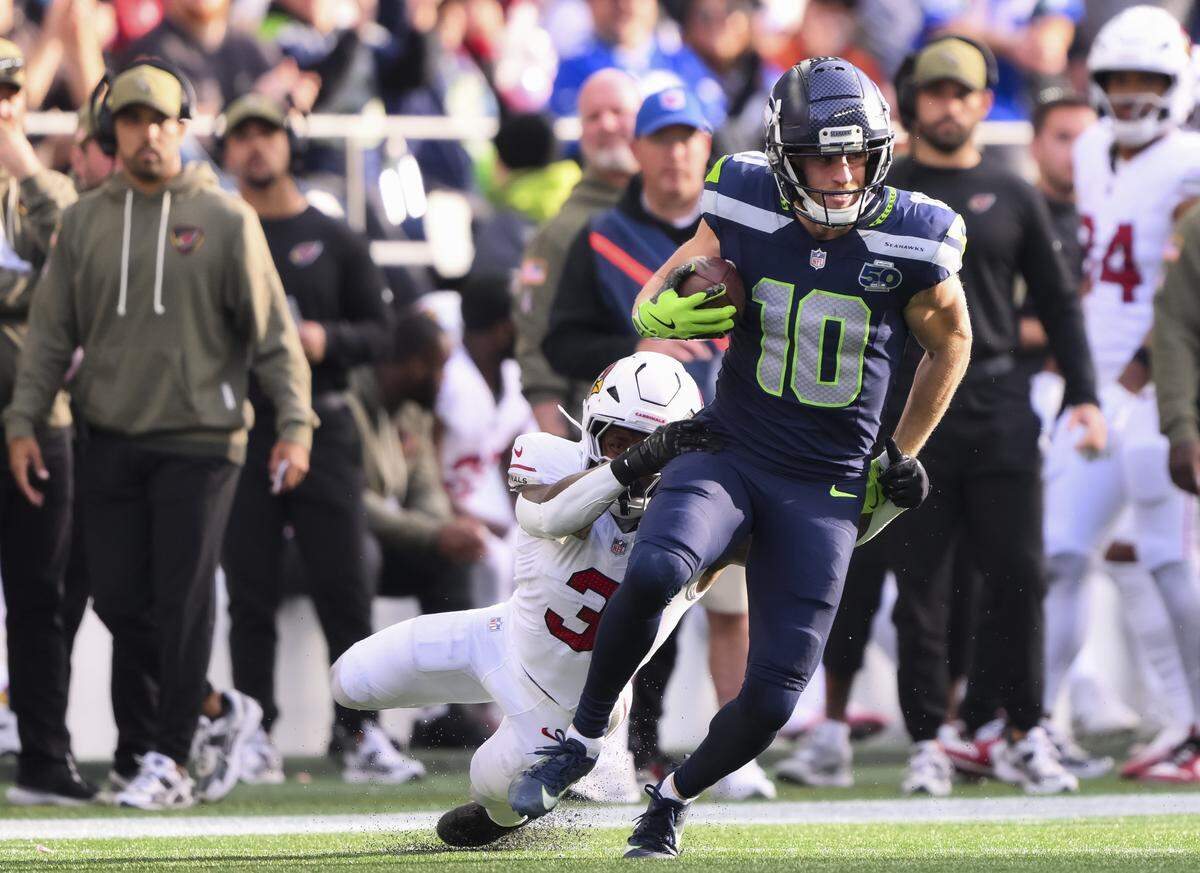 Seattle Seahawks wide receiver Cooper Kupp (10) slips Arizona Cardinals safety Budda Baker (3) on his way to a 67-yard pick up during the second quarter of the game at Lumen Field, on Sunday, Nov. 9, 2025, in Seattle.