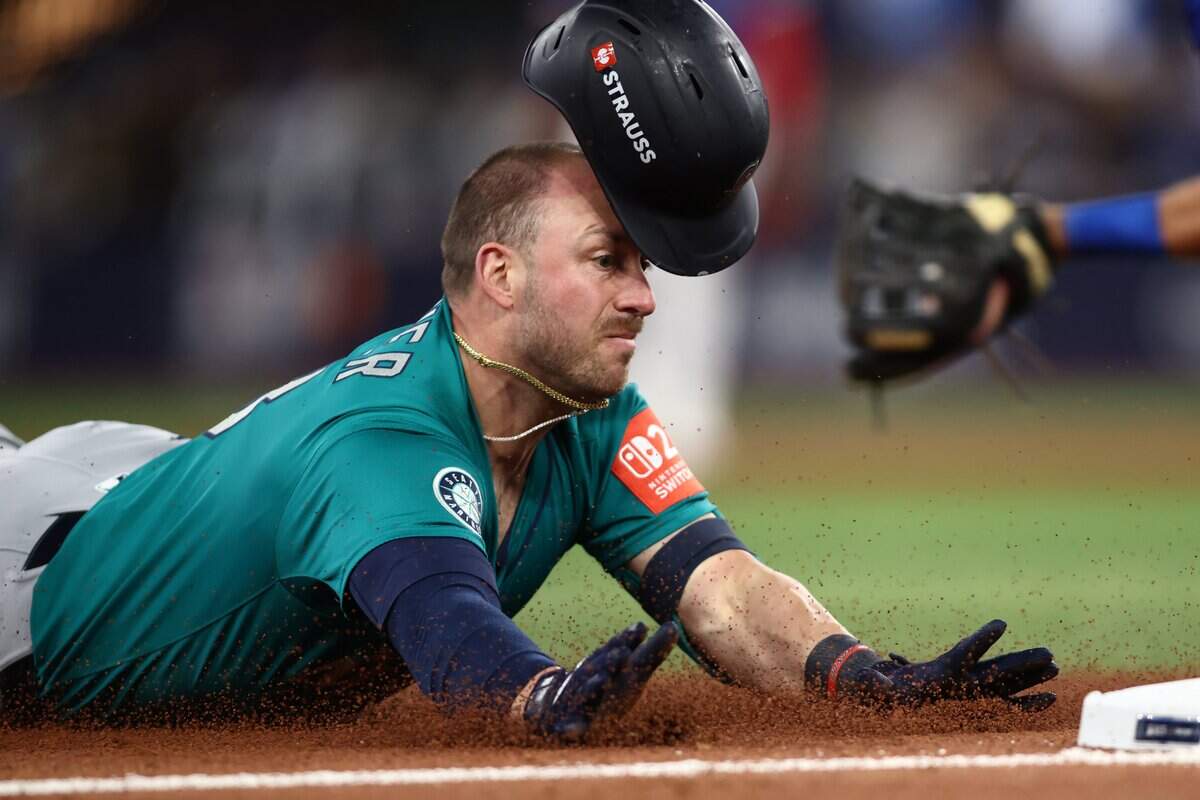 TORONTO, ONTARIO - OCTOBER 13: Mitch Garver #18 of the Seattle Mariners slides to third base after hitting a triple against the Toronto Blue Jays during the sixth inning in game two of the American League Championship Series at Rogers Centre on October 13, 2025 in Toronto, Ontario.  (Photo by Cole Burston/Getty Images)