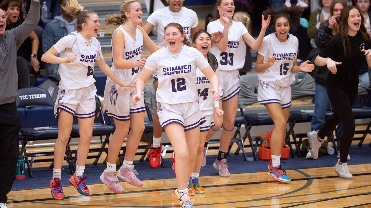 Sumner sophomore Parker Gould (12) and her Spartan teammates celebrate as time expires on their 50-48 victory over the Emerald Ridge Jaguars in Saturday night’s 4A SPSL girls basketball tournament championship game at Tacoma Community College in Tacoma, Washington, on Feb. 4, 2023.