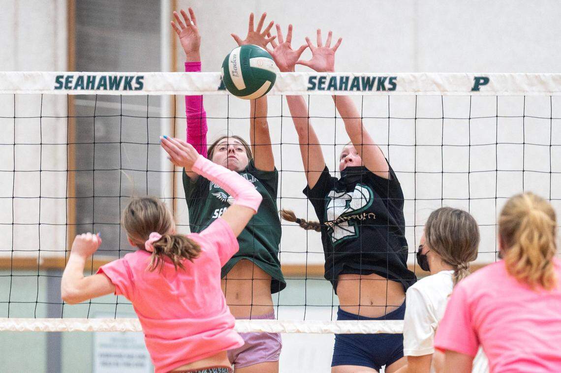 Peninsula’s Langley Griffin (left) and Kadence Stoddard team up to block a shot at the net during team drills at practice on Wednesday in Gig Harbor.