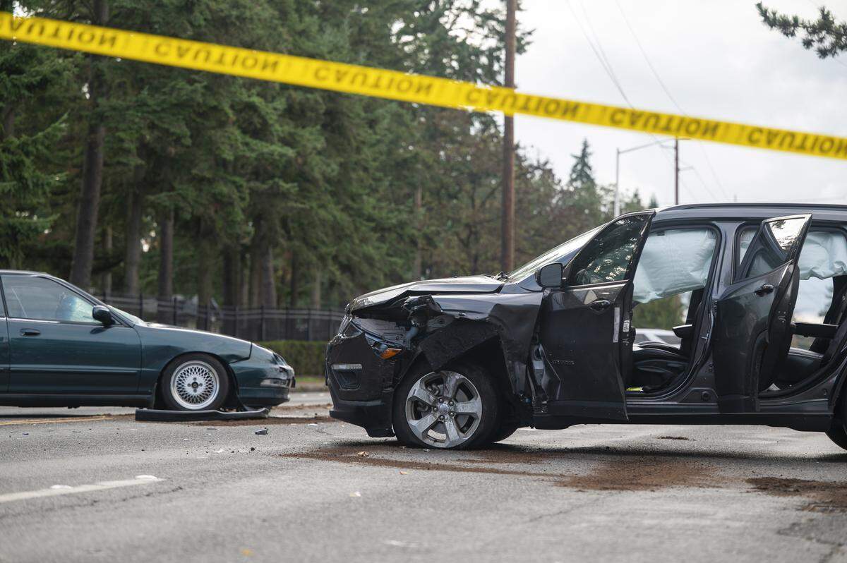 Two cars remain at the scene where a driver struck a pedestrian and another vehicle on 96th Street South on Monday, Nov. 10, 2025, in Tacoma, Wash. Initial reporting of the crash on Monday reported two people, one on a bicycle and another on a skateboard, were struck.
