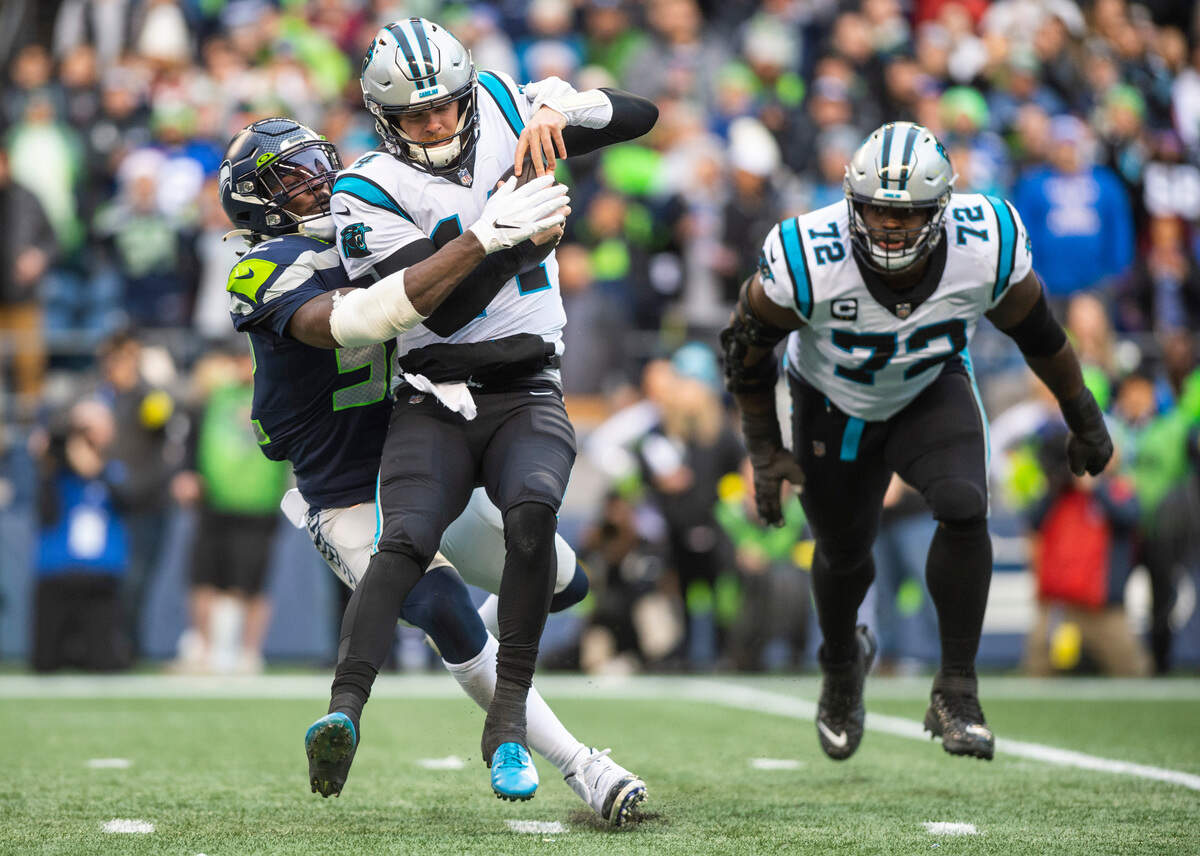Seattle Seahawks defensive end Darrell Taylor (52) sacks Carolina Panthers quarterback Sam Darnold (14) in the second quarter of an NFL game at Lumen Field in Seattle Wash., on Dec. 11, 2022.