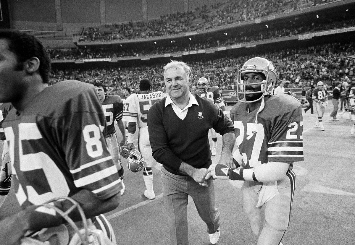 Seattle Seahawks coach Mike McCormack receives congratulations from Greggory Johnson (27), as the two head across the field following the end of their NFL game with Denver, Jan. 3, 1983, at the Kingdome. Seattle beat Denver on a last-minute play, 13-11.
