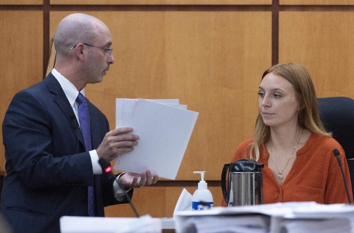 Defense attorney Jared Ausserer shows papers to Sara McDowell during the trial of Tacoma police officers Christopher Burbank, Matthew Collins and Timothy Rankine in the killing of Manny Ellis. Sara McDowell shot video of Ellis’ fatal encounter with police in March 2020.