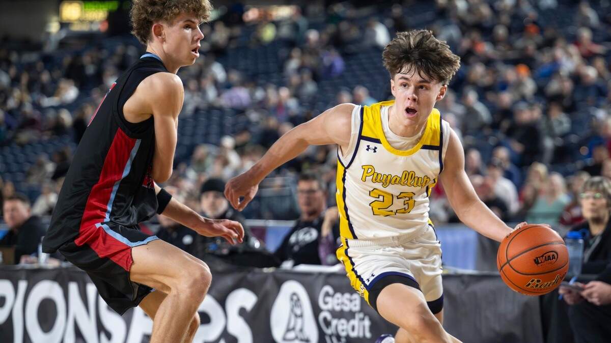 Puyallup guard Drew Jones (23) drives to the basket as West Valley guard Austin Birley (20) defends during the second quarter of a Class 4A state basketball tournament semifinal game at the Tacoma Dome on Friday, March 7, 2025, in Tacoma, Wash.