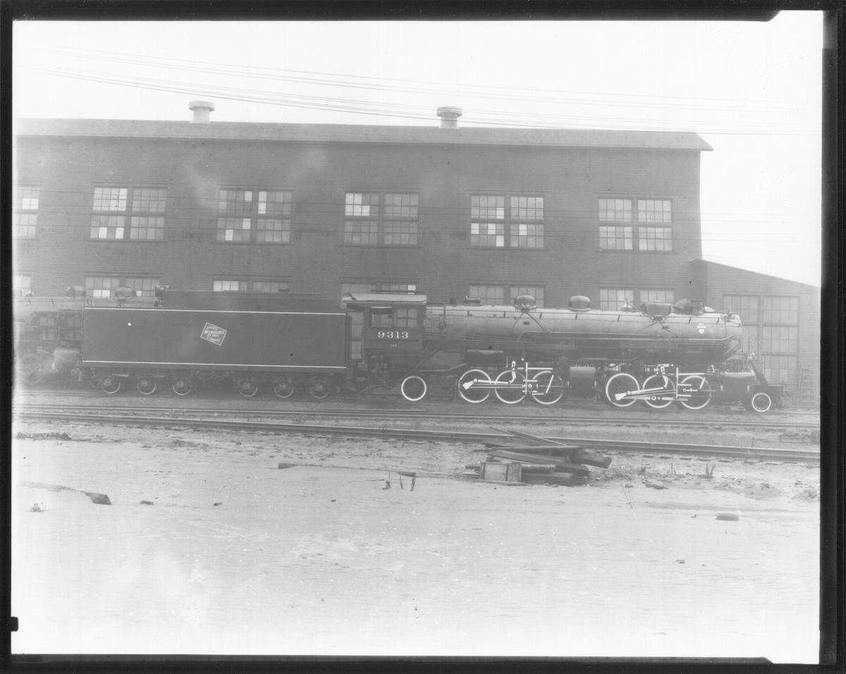 A photo of the Milwaukee Road freight building next to a train, dated 1909.