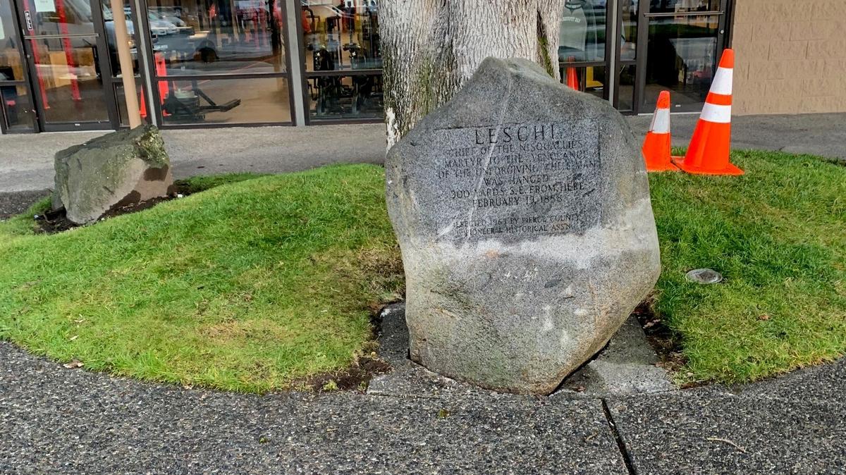 A granite boulder commemorating the execution of Nisqually Chief Leschi was righted Tuesday after it was knocked over last week from its site in a Lakewood strip mall.