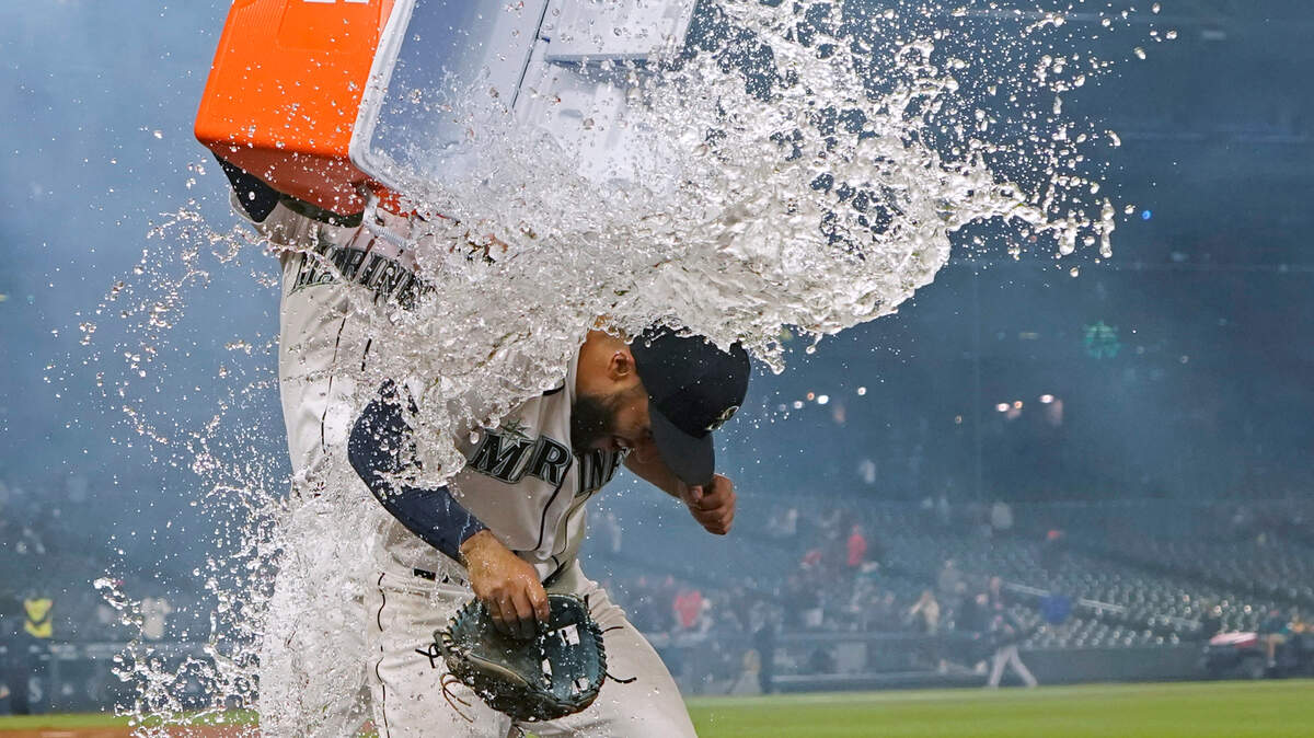 Seattle Mariners’ Abraham Toro, right, has a cooler of water dumped onto him by teammate Luis Torrens as Toro takes part in an interview after the team’s baseball game against the Houston Astros, Tuesday, Aug. 31, 2021, in Seattle. Toro hit a grand slam in the eighth inning to give the Mariners a 4-0 win. (AP Photo/Ted S. Warren)