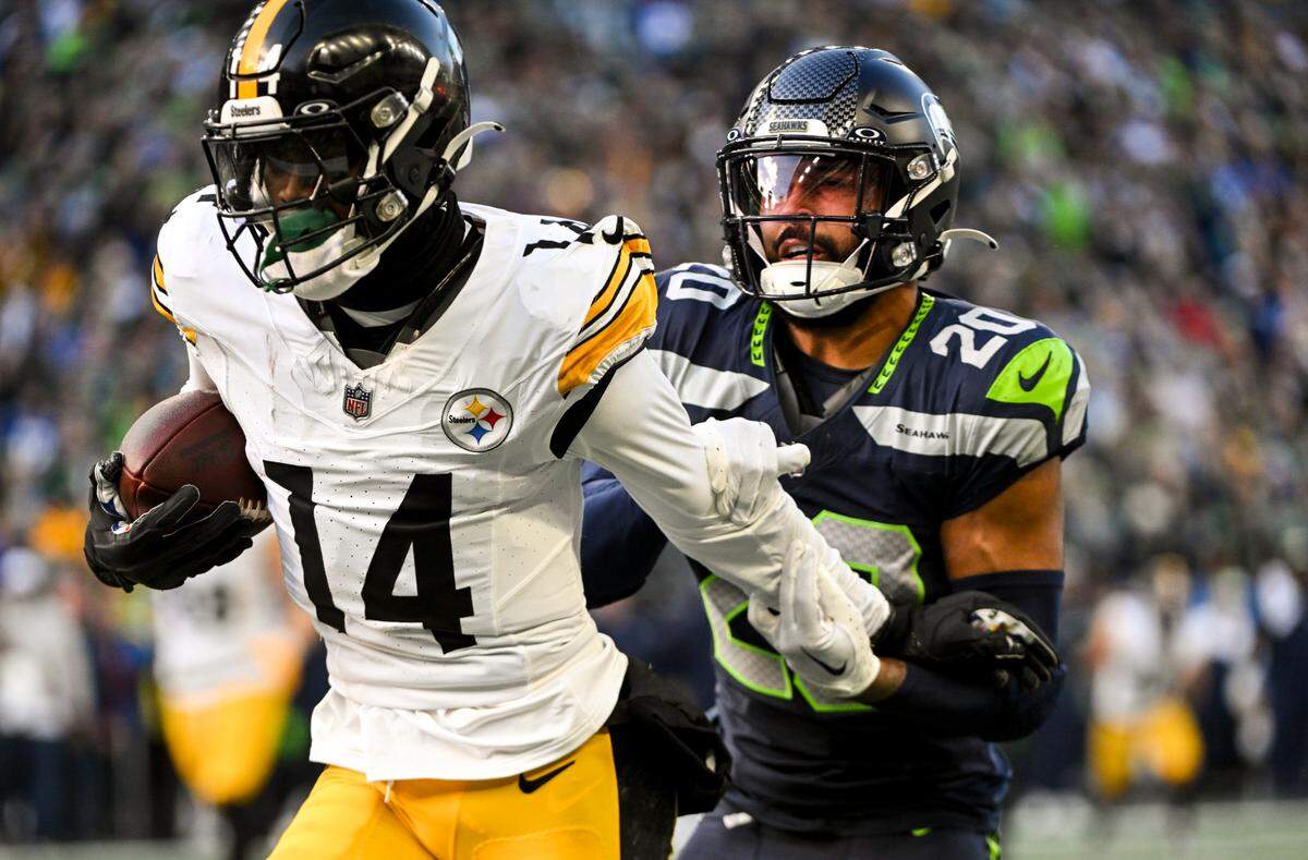 Pittsburgh Steelers wide receiver George Pickens (14) is tackled by Seattle Seahawks safety Julian Love (20) during the second quarter of the game at Lumen Field, on Sunday, Dec. 31, 2023, in Seattle, Wash.