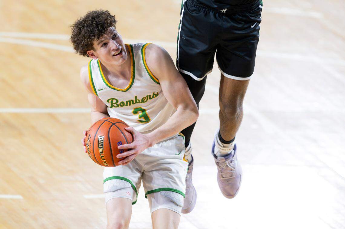 Richland’s Lance Horntvedt (3) goes underneath as Emerald Ridge’s Jamaize McGriff (20) jumps for the block during the second half of a Class 4A state basketball tournament first-round game at the Tacoma Dome on Wednesday, March 5, 2025, in Tacoma.