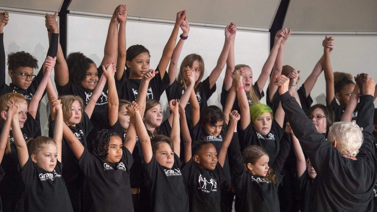 Singers with the Grant Troubadors raise their arms in unity after performing the number “One Nation” at the Martin Luther King Jr. Day celebration at the Tacoma’s convention center on Monday, Jan. 15, 2018.
