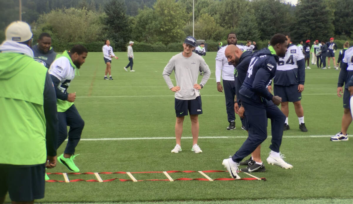 Linebacker Bobby Wagner (in white jersey) and wide receiver DK Metcalf (right) go through a foot-speed ladder competition with the defensive linemen during the walkthrough practice Aug. 9, 2023, the day before the Seahawks’ preseason opener against the Minnesota Vikings.