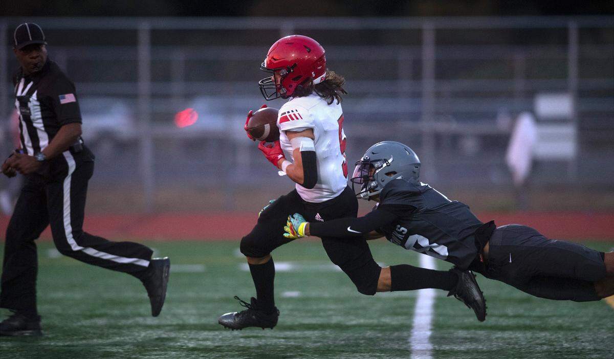 Yelm wide receiver Kyler Ronquillo pulls in a pass in front of River Ridge defensive back Jerrell Larkins during Friday night’s high school football game at South Sound Stadium in Lacey, Washington, on Sept. 24, 2021.