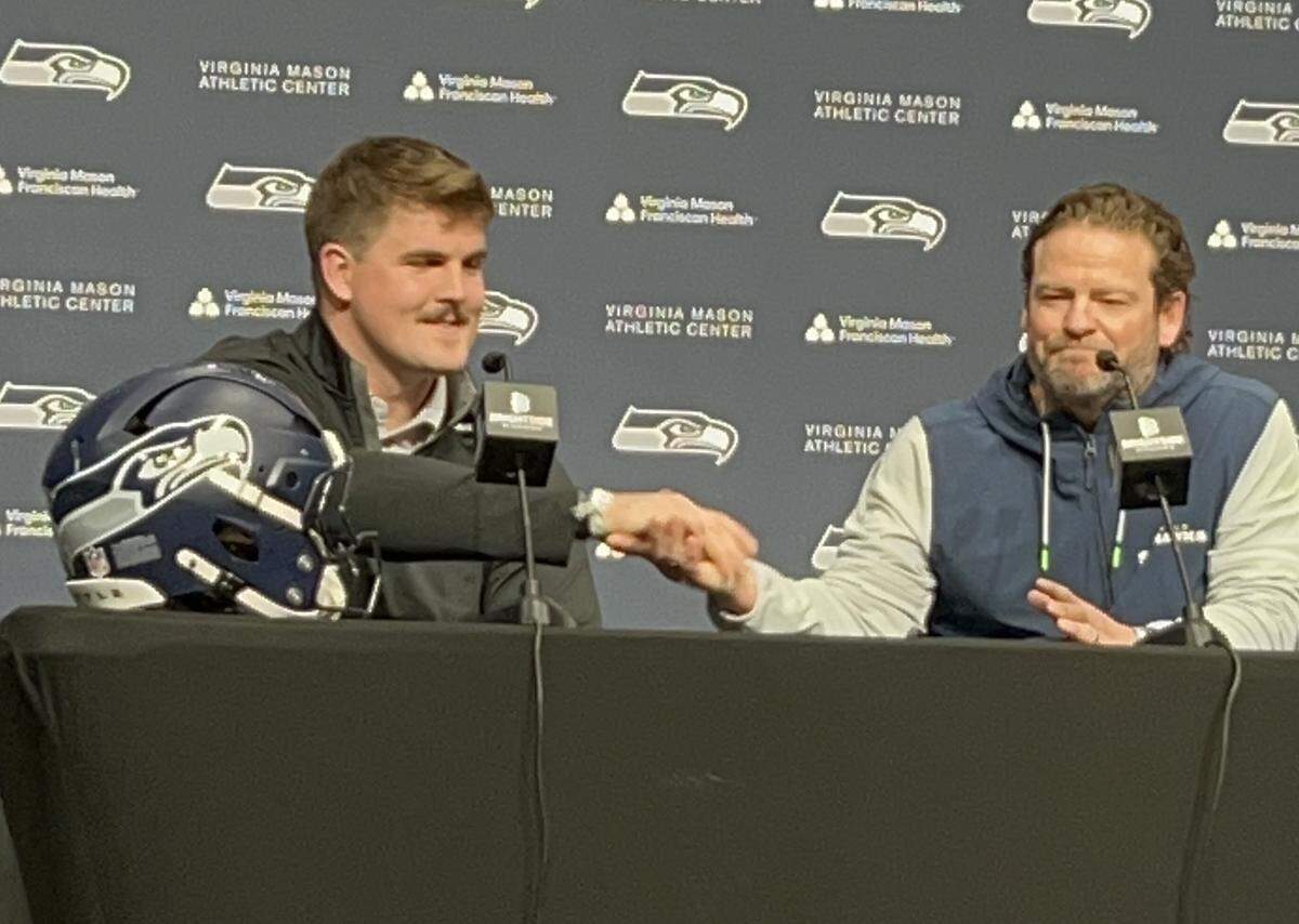 Rookie first-round NFL draft choice Grey Zabel (left) and general manager John Schneider shake hands as the Seahawks formally introduce their new starting left guard to Seattle at the Virginia Mason Athletic Center in Renton May 1, 2025.