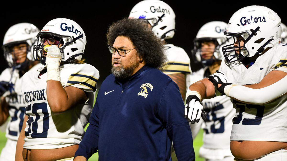 Decatur head coach Matthew Vaeena and players walk off the field during the first half of the game against the Federal Way Eagles at Federal Way Memorial Stadium, Thursday, Oct. 26, 2023, in Federal Way, Wash.