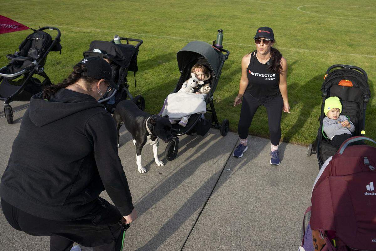 Fit4Mom University Place owner Jenn Fukuwa, center, demonstrates form for an exercise during a group workout on Thursday, Oct. 9, 2025, at Cirque Park in University Place, Wash.