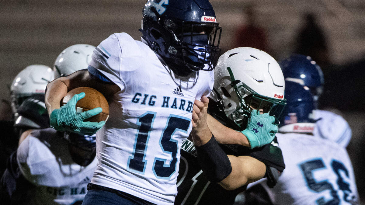 Gig Harbor’s Colin Montgomery fights for extra yards as Peninsula’s Duren Miller tries to tackle him during the first quarter. The Peninsula Seahawks played the Gig Harbor Tides in the annual Fishbowl rivalry game at Roy Anderson field in Purdy, Wash., on Friday, Feb. 19, 2021.