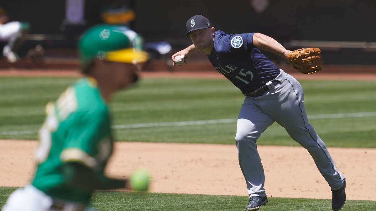 Seattle Mariners third baseman Kyle Seager (15) throws out Oakland Athletics’ Stephen Piscotty, left, at first base during the fourth inning of a baseball game in Oakland, Calif., Wednesday, May 26, 2021. (AP Photo/Jeff Chiu)