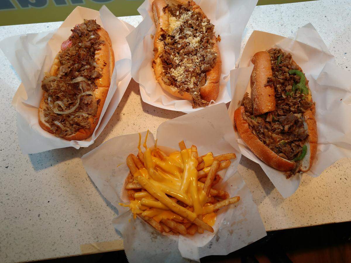 From upper left, a Cheesesteak Bomb, an Atomic Garlic Parm and a South Philly sandwich from Straight From Philly in downtown Tacoma. In front is an order of Atomic Fries.