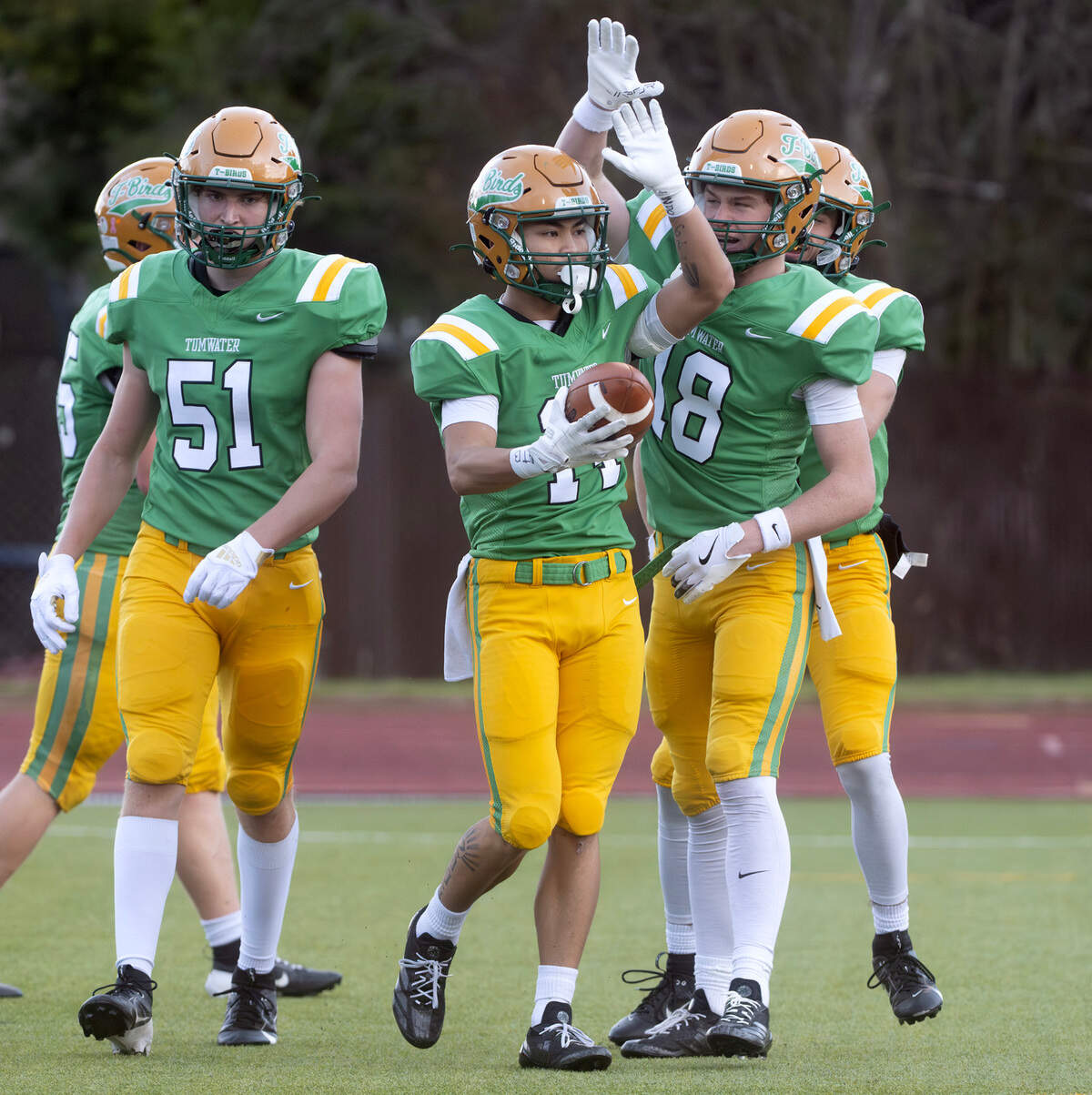 Tumwater’s Van Hannukame (51), Sunny Nguyen and Wyatt Chase (18) celebrate Nguyen’s touchdown reception during Satuday afternoon’s state playoff game against the Sehome Mariners at Tumwater District Stadium in Tumwater, Washington, on Friday, Nov. 23, 2024. Tumwater won the game, 70-7, to advance to the state semifinals.