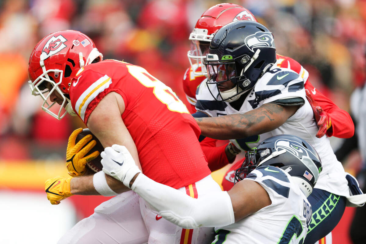 Seattle Seahawks linebacker Jordyn Brooks (56) and safety Quandre Diggs (6) tackle Kansas City Chiefs tight end Travis Kelce (87) during the fourth quarter on Saturday, Dec. 24, 2022, in Kansas City, MO.