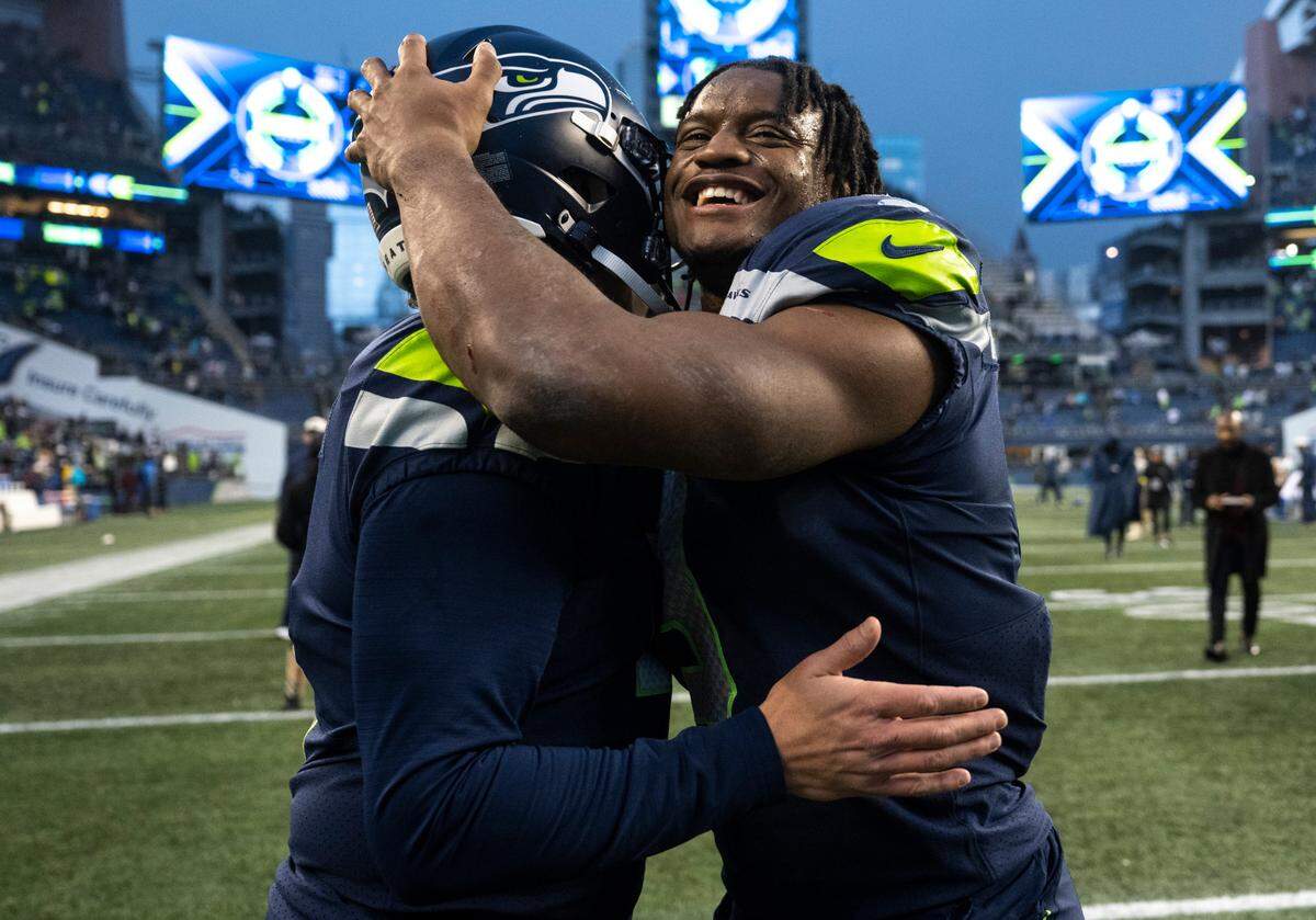 Seattle Seahawks running back Kenneth Walker III (9) hugs Seattle Seahawks place kicker Jason Myers (5) after Myers kicked the game winning field goal in overtime at the end of an NFL game against the Los Angeles Rams at Lumen Field in Seattle, Wash. on Jan. 8, 2023. The Seahawks defeated the Rams in overtime 19-16.