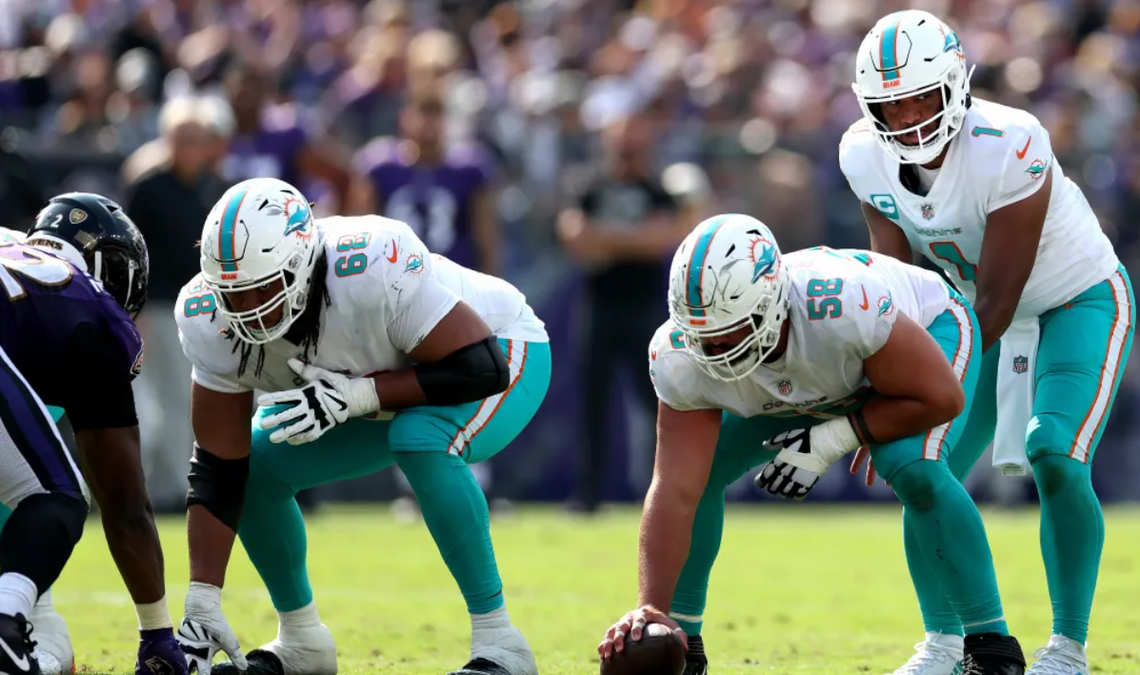 Connor Williams (58) snapping to Dolphins quarterback Tua Tagovailoa (1) in Miami’s game against the Ravens Sept. 18, 2022, in Baltimore.