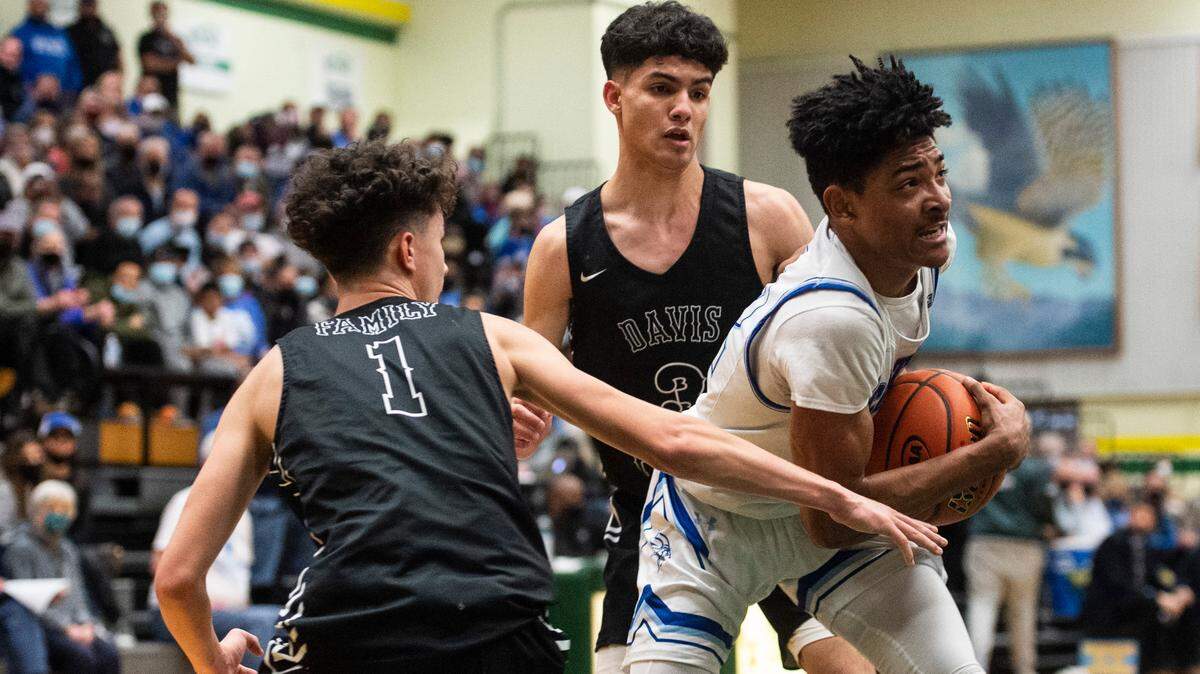 Curtis’s guard Cinque Maxwell (12) tries to keep control of the ball as Davis’s guard Brandon Lee Jr. (1) tries to steal it during the high school boys 4A basketball state tournament regional round game at Foss High School in Tacoma, Wash. on Saturday, Feb. 26, 2022.
