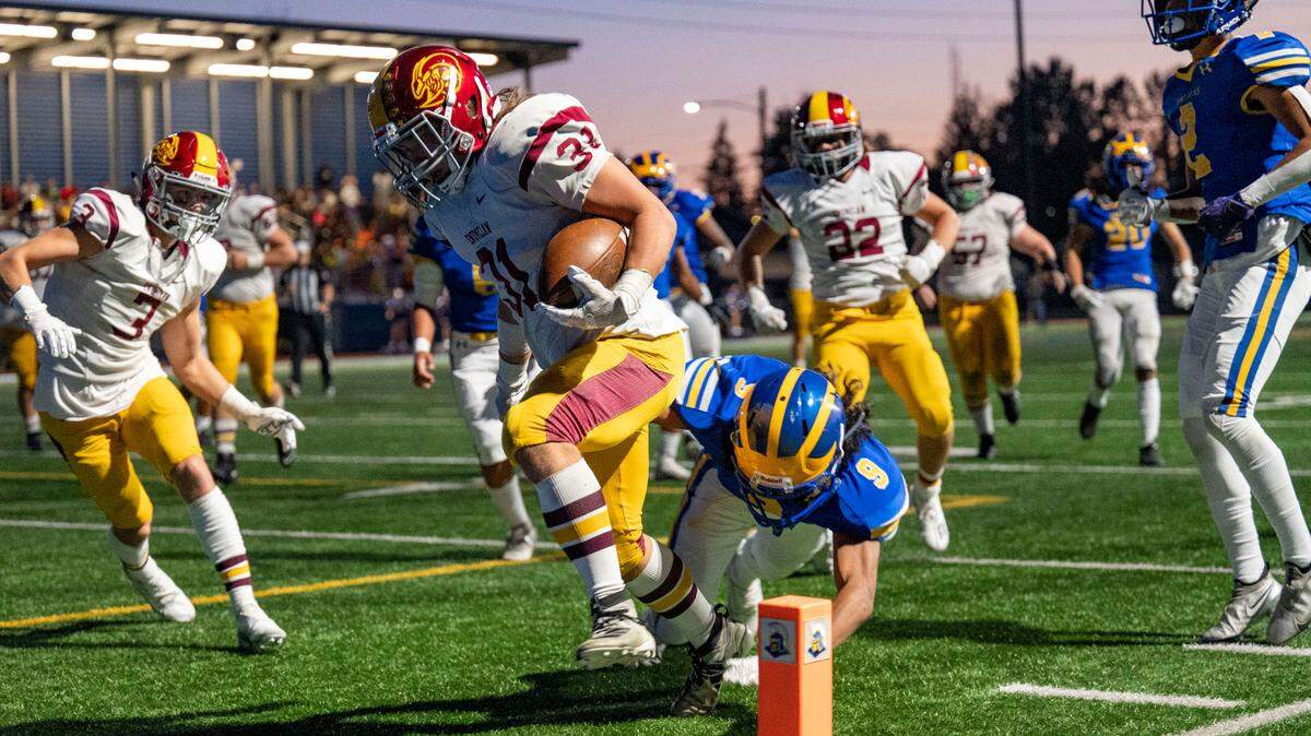 Enumclaw running back Emmit Otero breaks through a tackle attempt by Fife’s Drew Francis as he scores a touchdown in the second quarter of 2A SPSL game on Thursday, Sept. 22, 2022, at Fife High School in Fife, Wash.