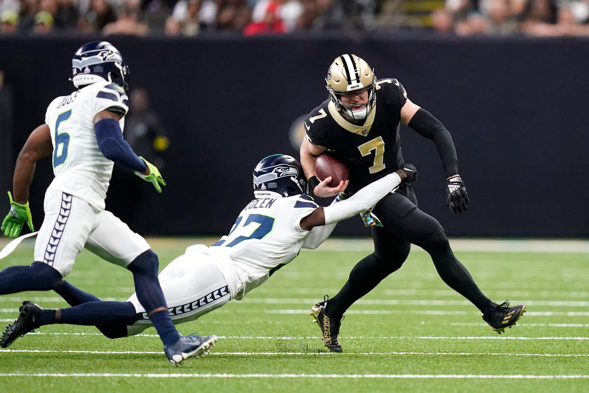 New Orleans Saints’ Taysom Hill (7) carries the ball as Seattle Seahawks cornerback Tre Brown tries to make the tackle during an NFL football game in New Orleans, Sunday, Oct. 9, 2022. (AP Photo/Gerald Herbert)