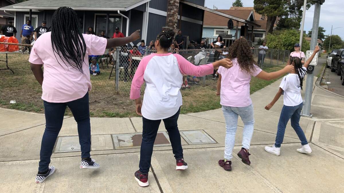 Members of Vision Step Team entertain youth and their families Saturday at a Hilltop Tacoma party where every child was given a pair of brand new Nike shoes. The giveaway was organized and paid for by Motivating Our Children 2 Honor Academics.