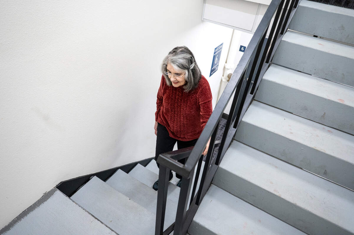 Kathleen Waters, president of the Tenant Association at Wright Park House, climbs the stairs of the apartment complex on Tuesday, May 13, 2025, in Tacoma.