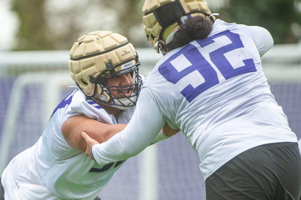 Washington defensive lineman Ulumoo Ale (left) works on rushing drills with fellow lineman Now Ngalu at spring practice on Wednesday, March 30, 2022, at Husky Stadium in Seattle, Wash.