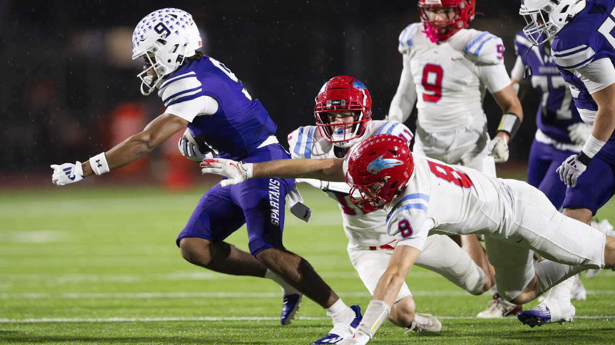Sumner running back Lance McGee (9) carries the ball against two Eastmont defenders during the first half of the game, at Sunset Chev Stadium on Friday, Nov. 7, 2025, in Sumner, Wash.