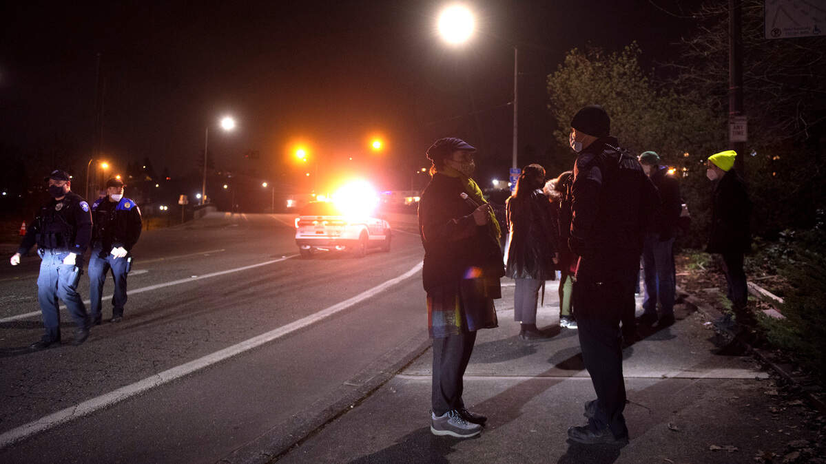 Tacoma police talk with witnesses after a woman protesting the Tacoma Safe meeting was hit by a hit-and-run driver outside the LeMay Car Museum in Tacoma, on Wednesday, Jan. 26, 2022.