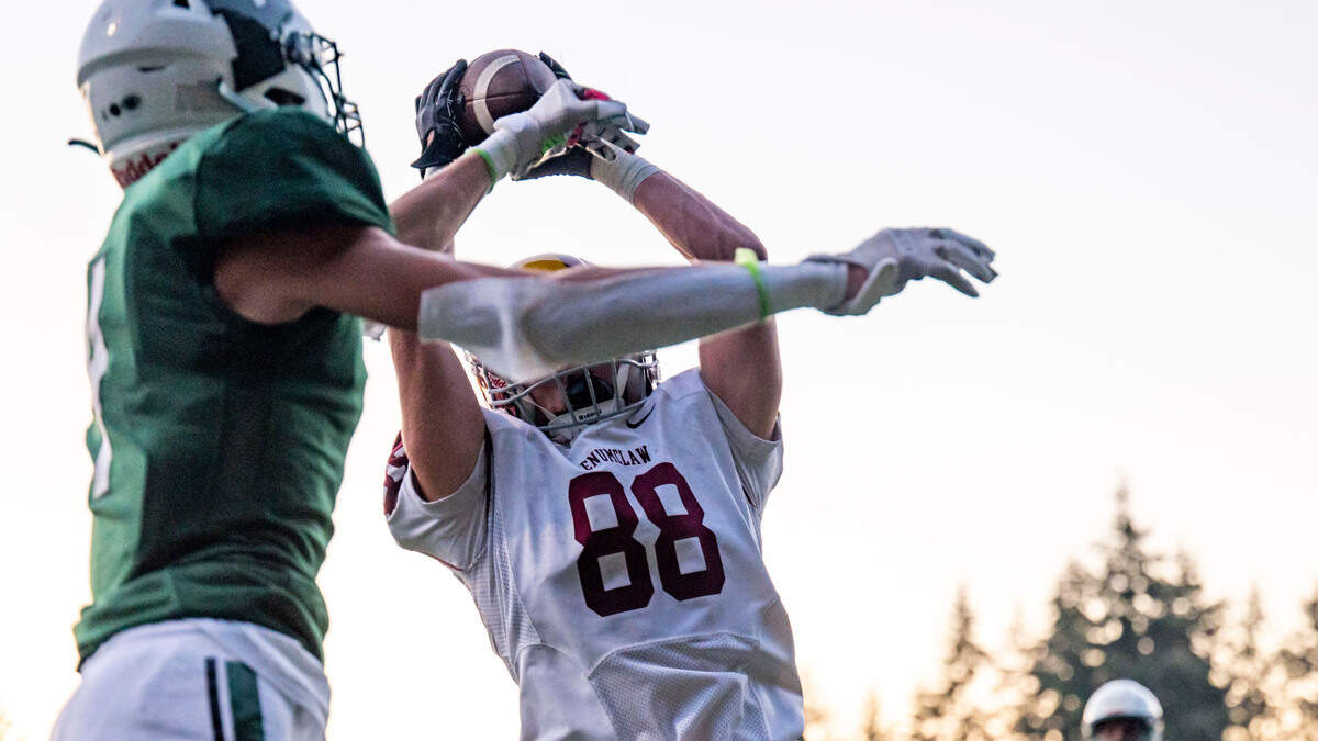 Enumclaw receiver Austin Paulson catches a touchdown pass from Gunnar Trachte as Peninsula’s Ethan Fias defends during the second quarter of a nonleague game on Thursday, Sept. 1, 2022, at Roy Anderson Field in Gig Harbor Wash.