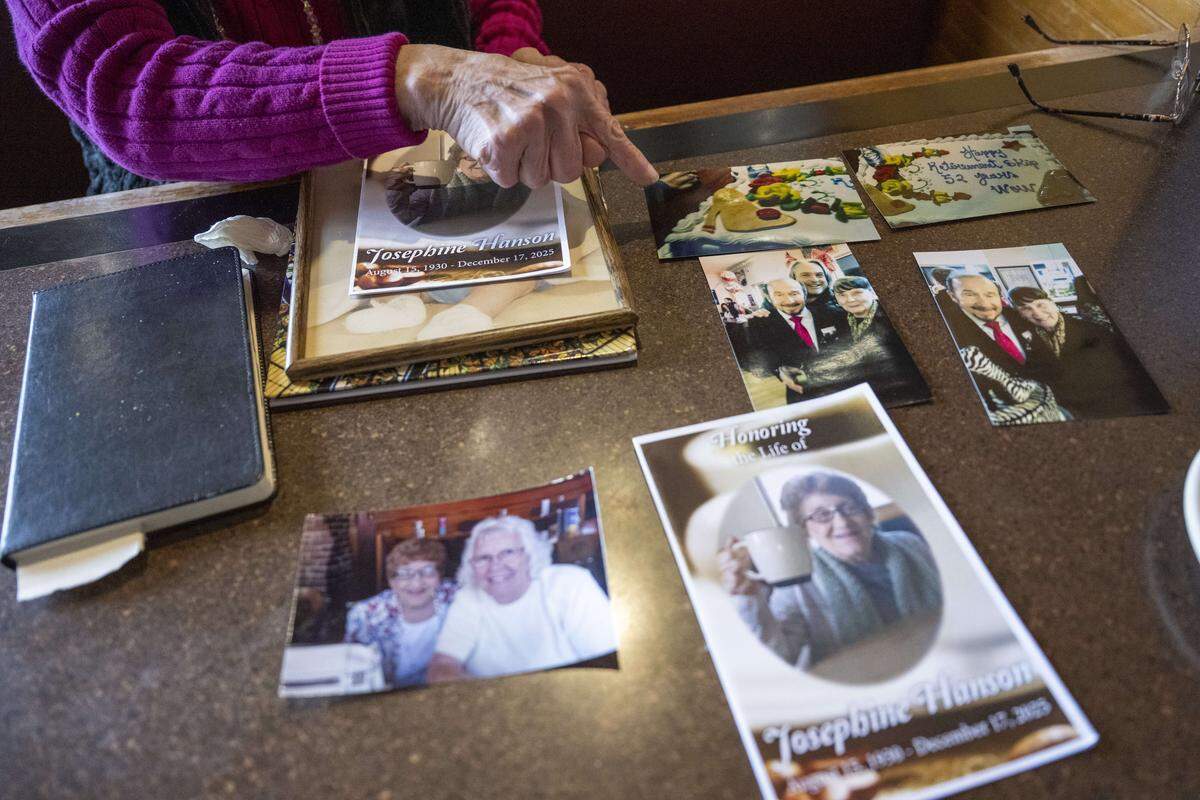 June Craig shares photos of Skip Butler and other members of the Bon crew that have passed on from a seat at the Ram Restaurant on Thursday, Feb. 19, 2026, in Tacoma, Wash.