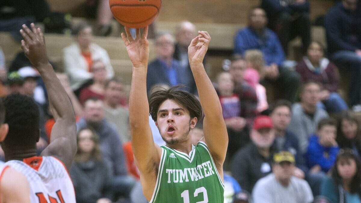 Tumwater’s Ty Gilliland lanches a jumper over Centralia defender Michael Ajoge during Saturday evening’s boys basketball game at Centralia High School on Jan. 6, 2018.