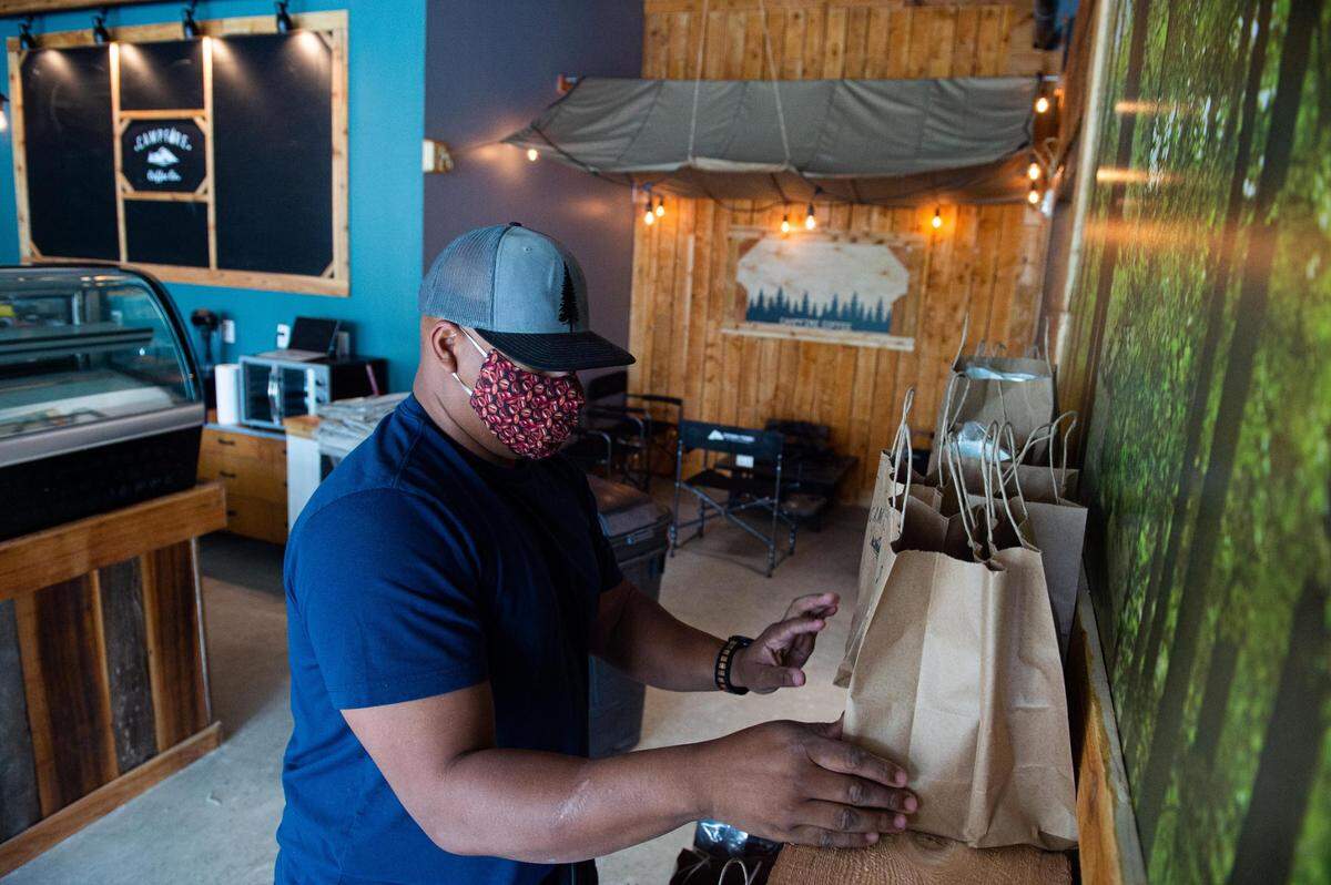 Quincy Henry prepares pick-up bags of coffee beans at Campfire Coffee in Tacoma, Wash., on Thursday, July 23, 2020.