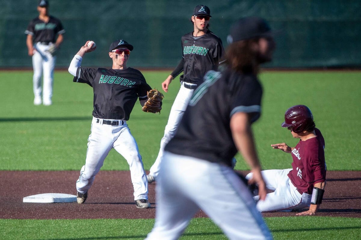 Auburn shortstop Ethan Smetheram attempts to turn a double play as he gets the force out at second base on Mercer Island’s Austin Cupic during the bottom of the fifth inning of a State 3A playoff quarterfinal on Saturday, May 21, 2022, at Auburn High School in Auburn, Wash.