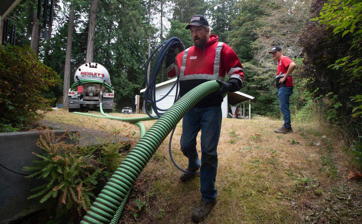 Hemley’s Septic Service maintenance specialist William Schmidt prepares to clean out a septic tank at a home on the Key Peninsula on Aug. 13.